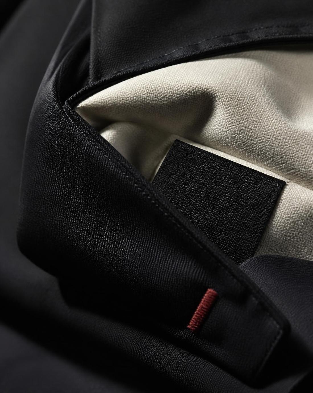Detalhe de costura e etiqueta interna de uniforme corporativo